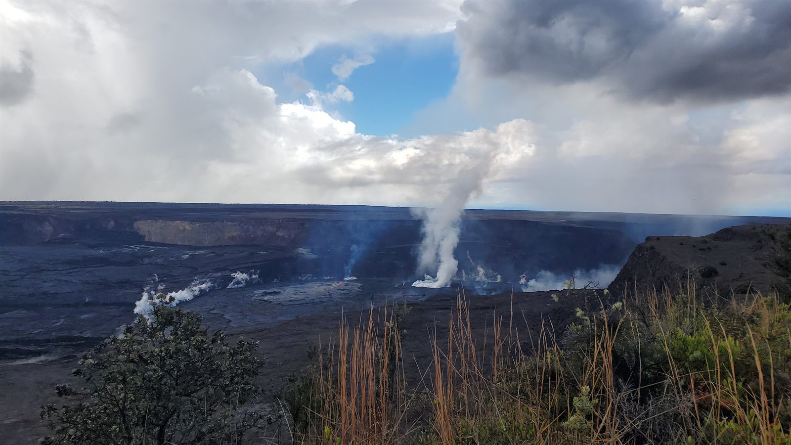 Steam rising from the Kilauea caldera under clouds in Hawaii Volcanoes National Park