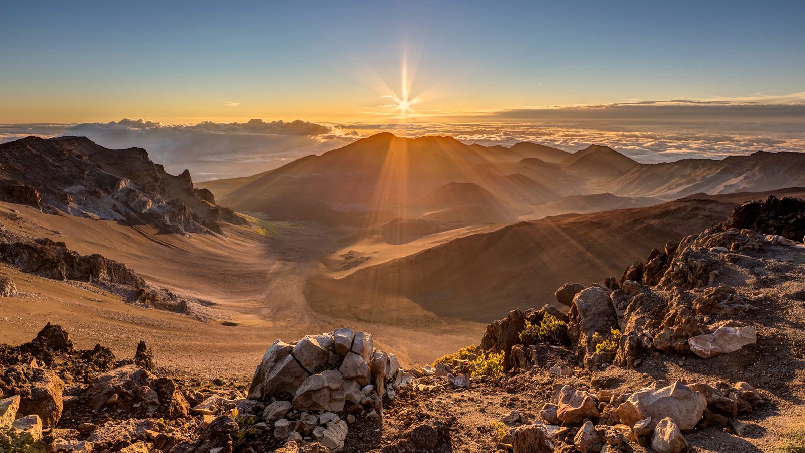 Sunrise over the Haleakala crater rim above the clouds on Maui, a cold spot to remember when deciding what to pack for Hawaii in October